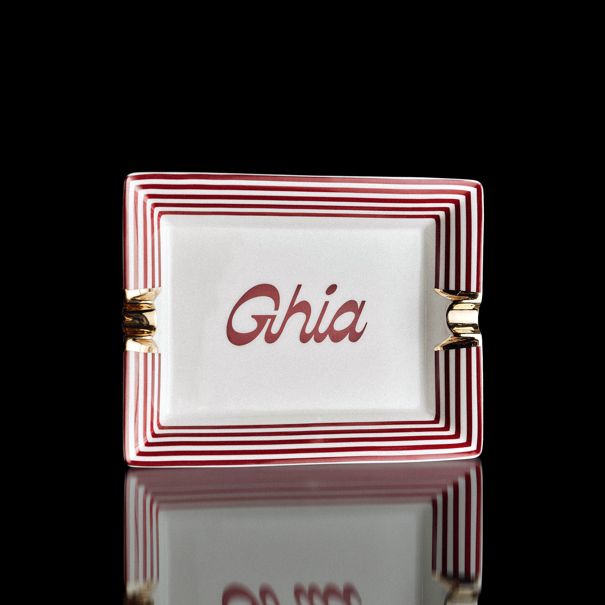 Ghia vide-poche ceramic tray with red and white striped border, gold accents and Ghia script in the center
