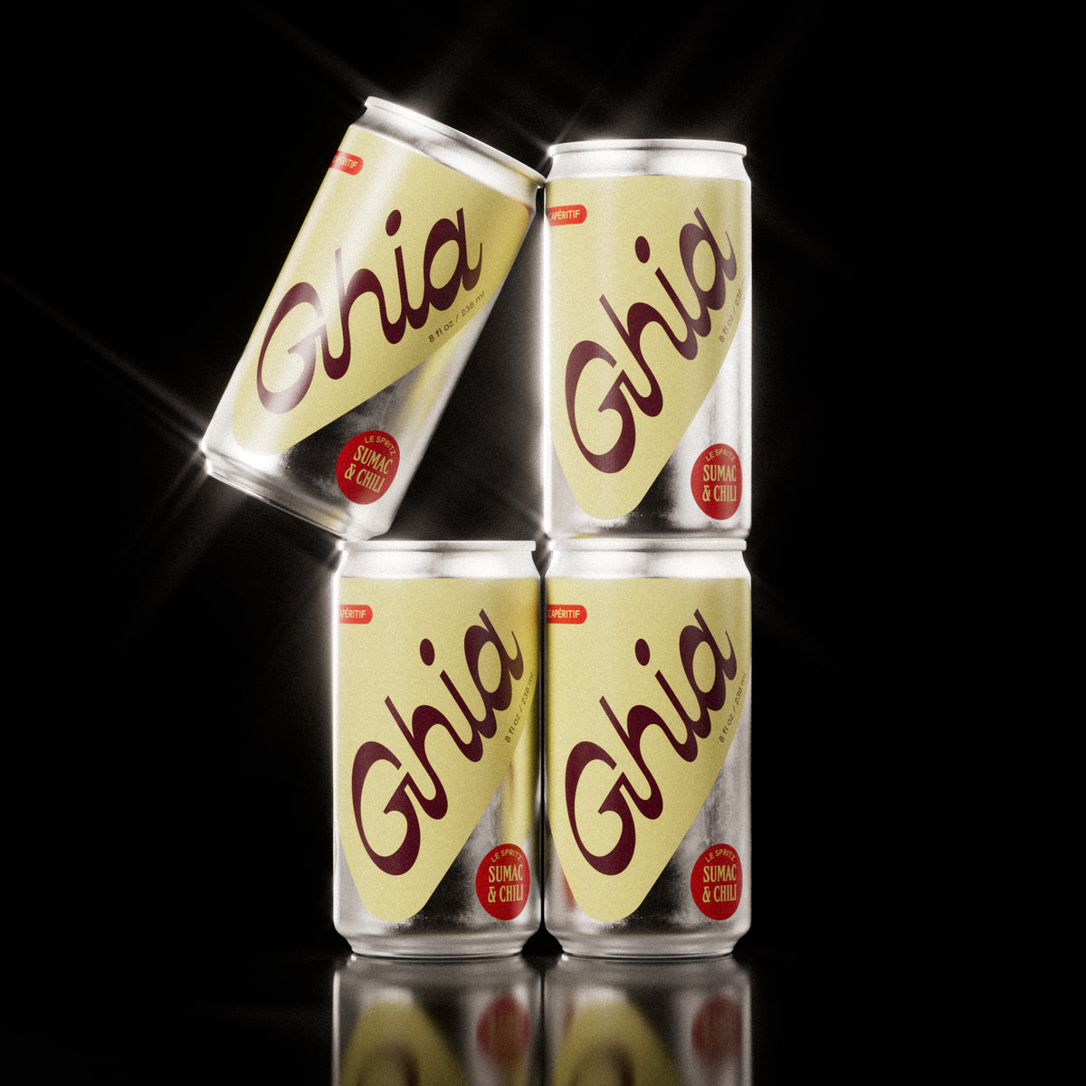 Four Ghia Sumac & Chili non-alcoholic spritz cans in a pyramid stack with bold yellow labels and red “Sumac & Chili” flavor badges, set against a black background.