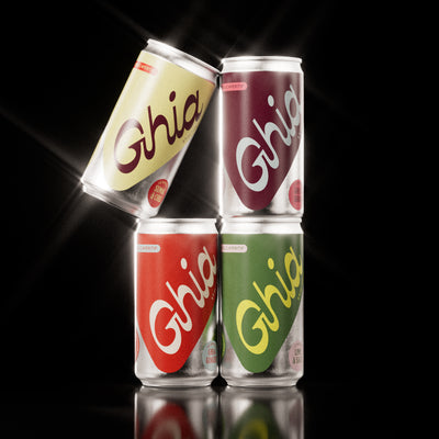 Four stacked Ghia spritz cans in Sumac & Chili, Soda, Ginger, and Lime & Salt flavors
