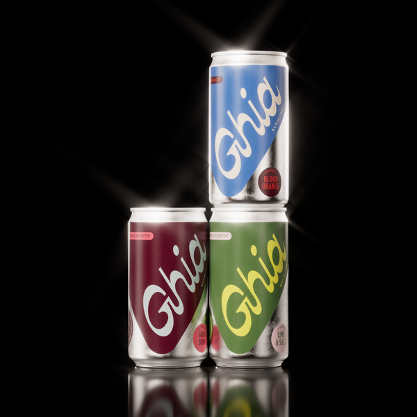 Three Ghia non-alcoholic spritz cans in blue, burgundy, and green, featuring Blood Orange, Ghia Soda, and Lime & Salt flavors, arranged against a black background.