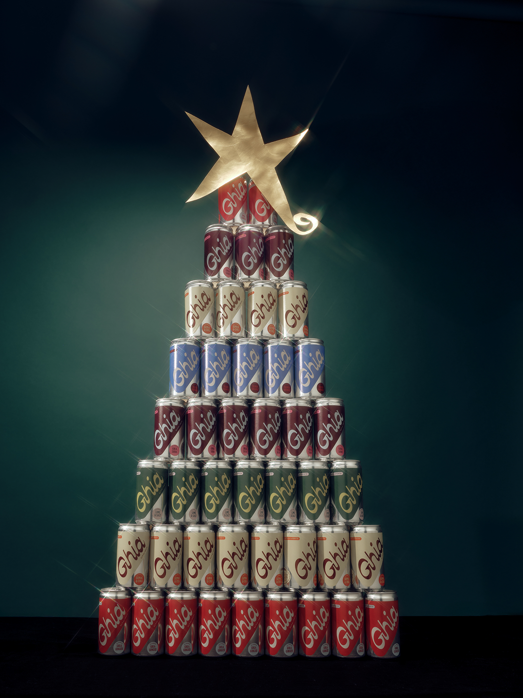 Ghia Le Spritz cans stacked into a Christmas tree shape topped with a gold star