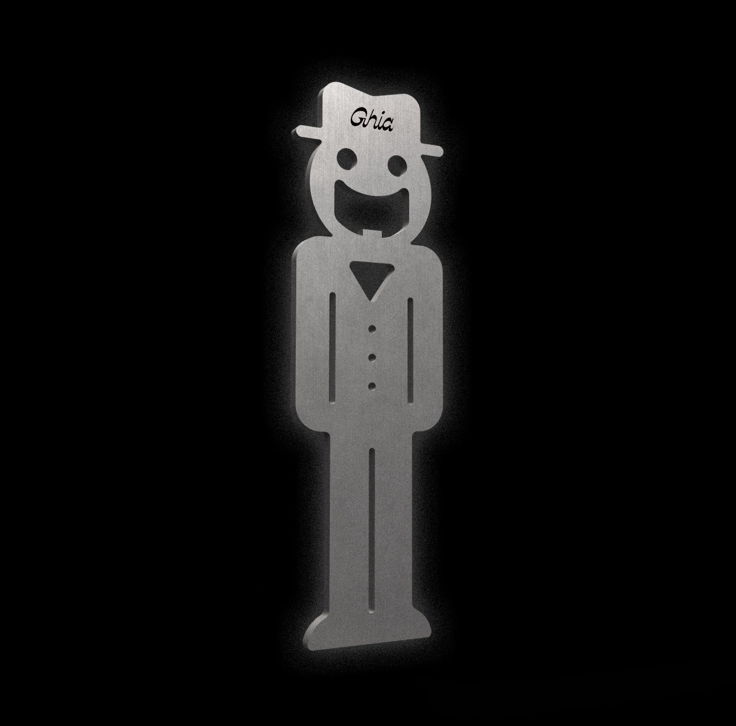 A Ghia-branded metal figure with a smiling face, hat, and buttoned outfit, crafted from brushed stainless steel.